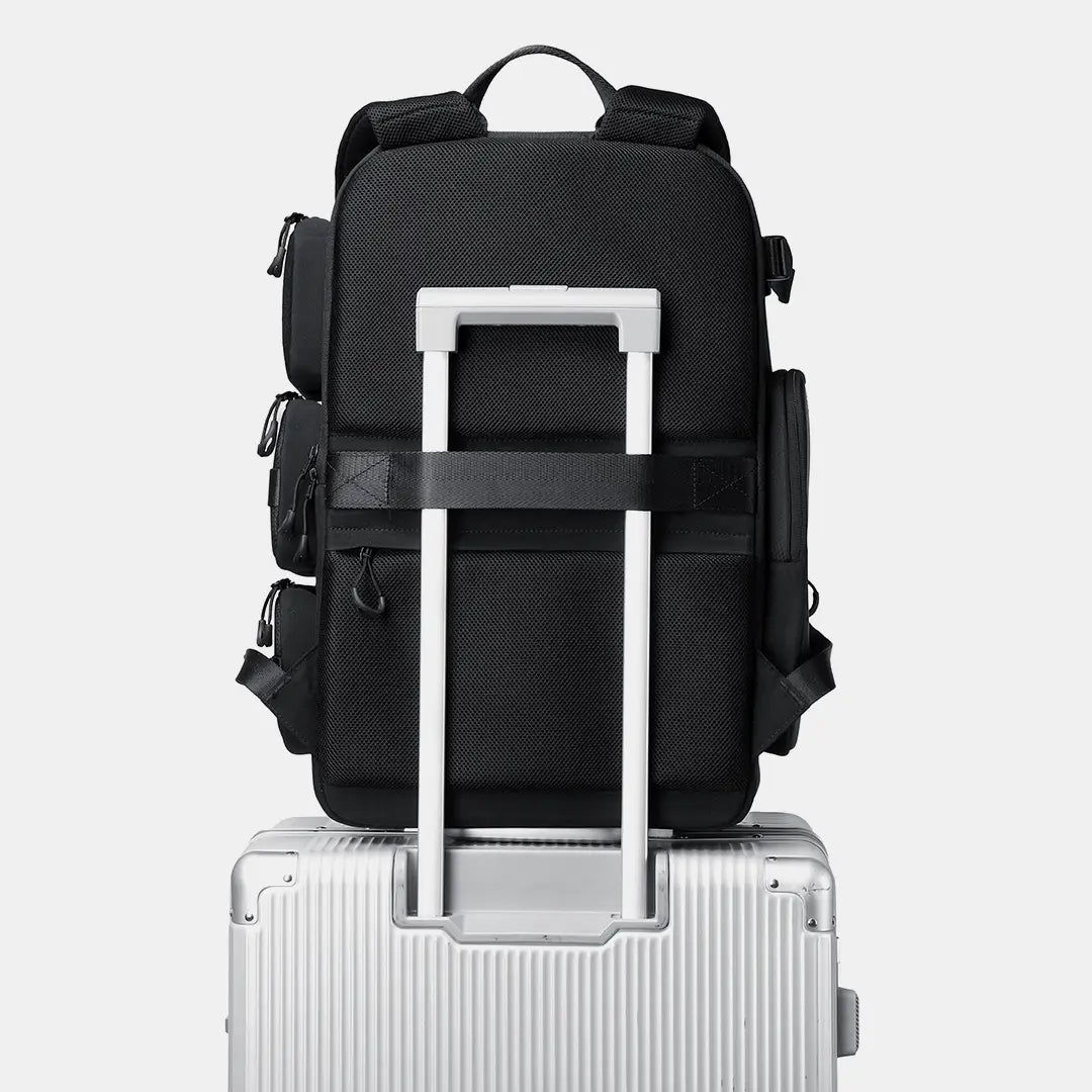 Black training backpack mounted on luggage trolley sleeve for travel