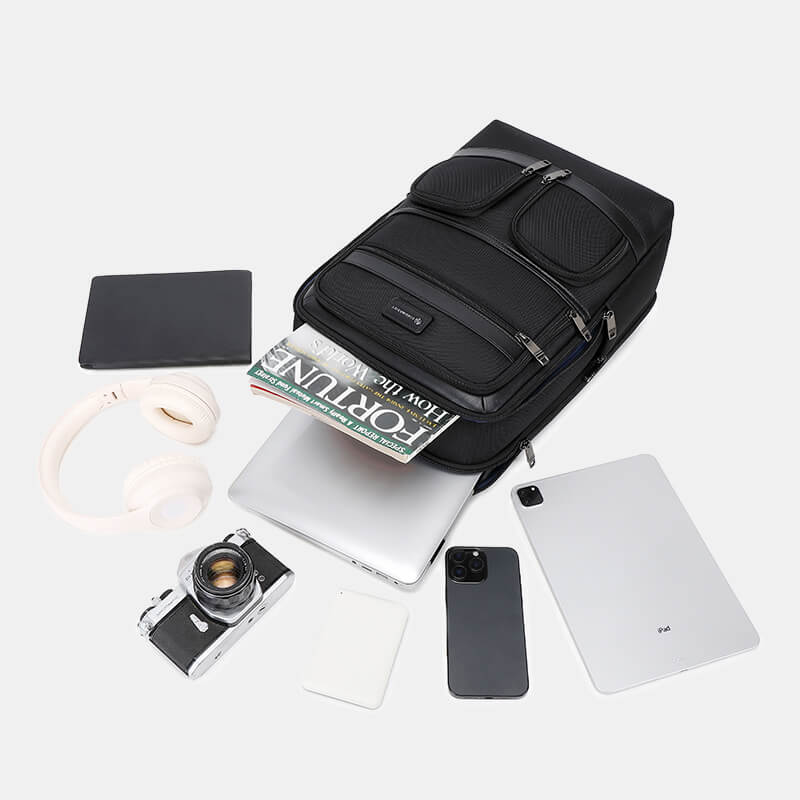 Black backpack with various items on a white background