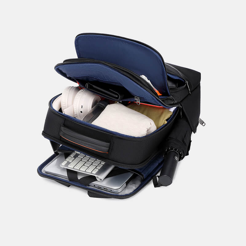 Black backpack with compartments containing a laptop, keyboard, and other items on a white background