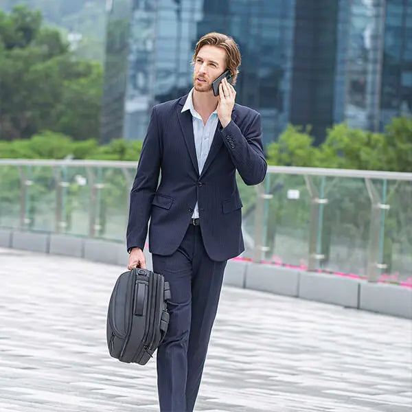 Man carrying the Cinomadist backpack in briefcase style while walking outdoors