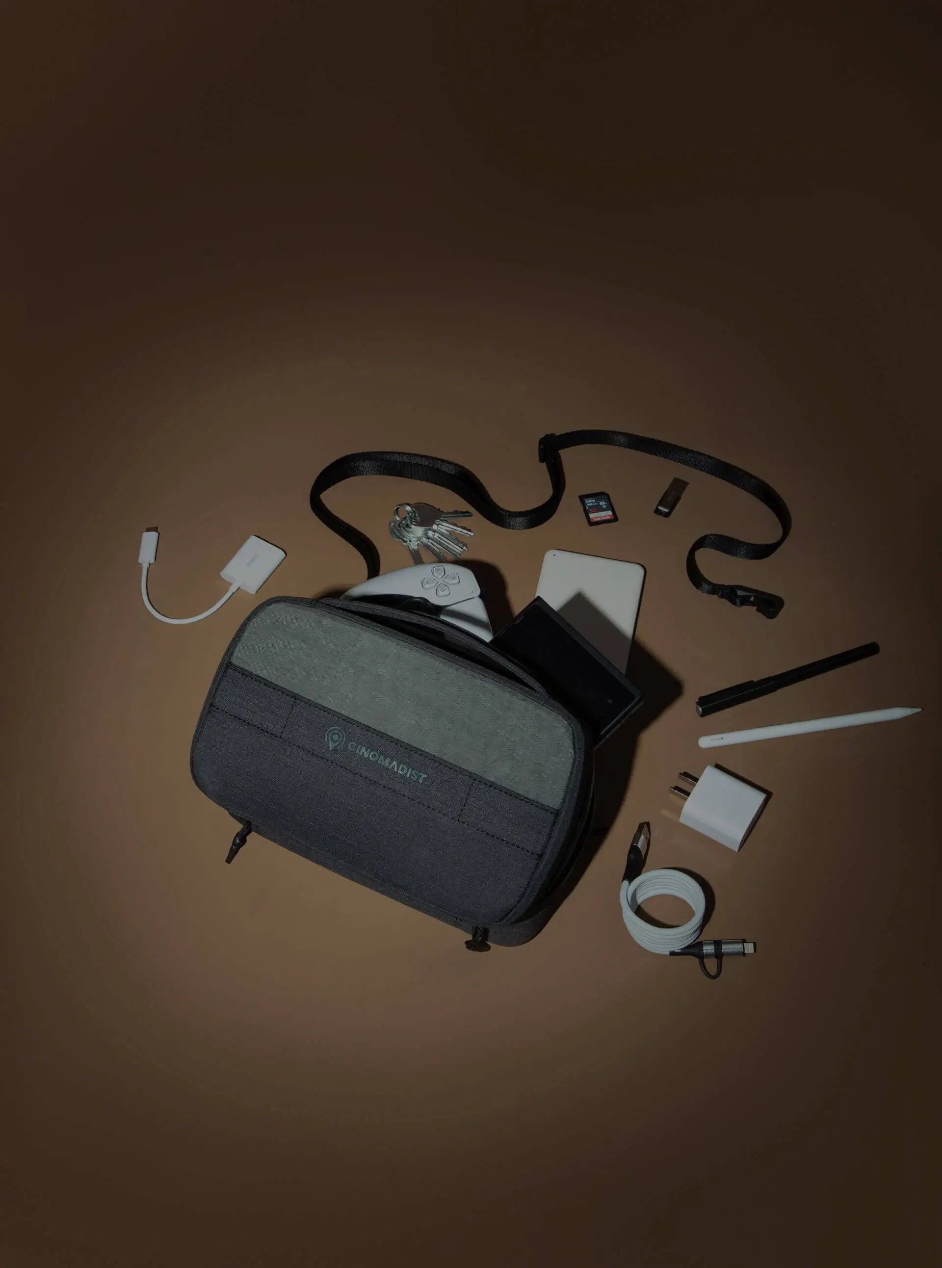 Collection of travel accessories including a gray toiletry bag on a brown background