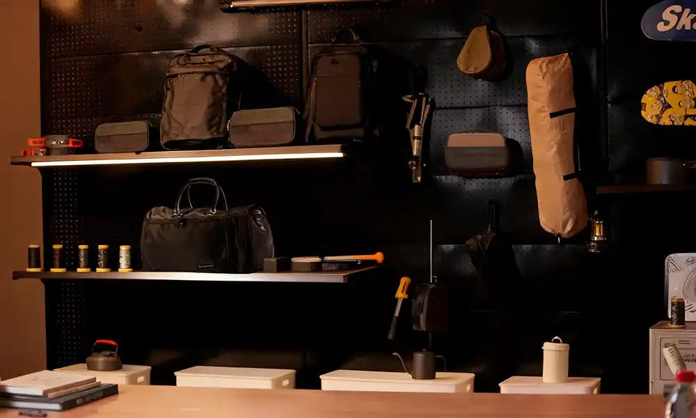 Collection of travel accessories including a gray toiletry bag on a brown background