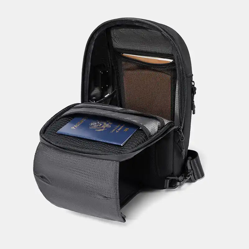 Black sling with a compartment holding a passport on a light gray background
