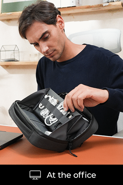 A hand retrieving a charging cable from the digital organizer bag.