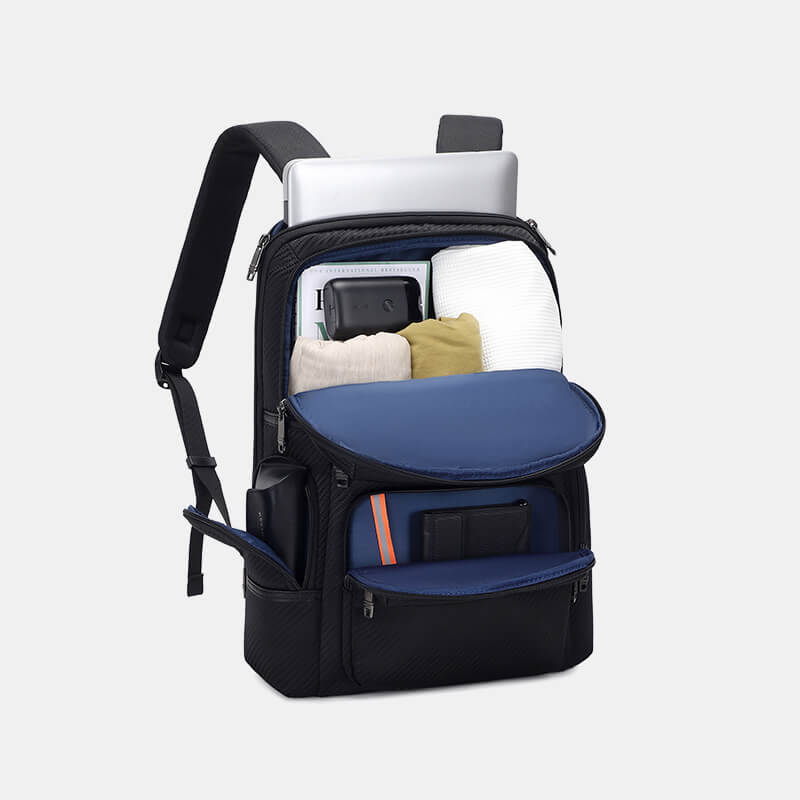 Black backpack with compartments containing a laptop, phone, and other items on a light gray background