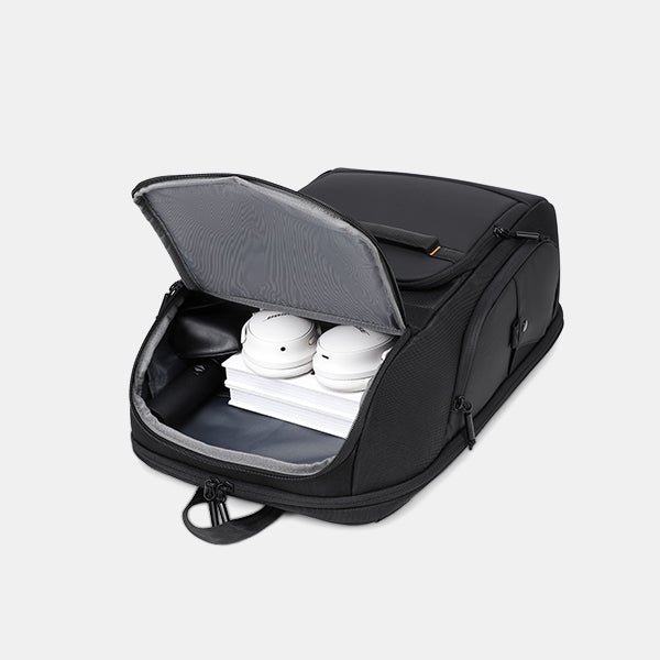 Black backpack with open lid showing white shoes and books inside on a light gray background