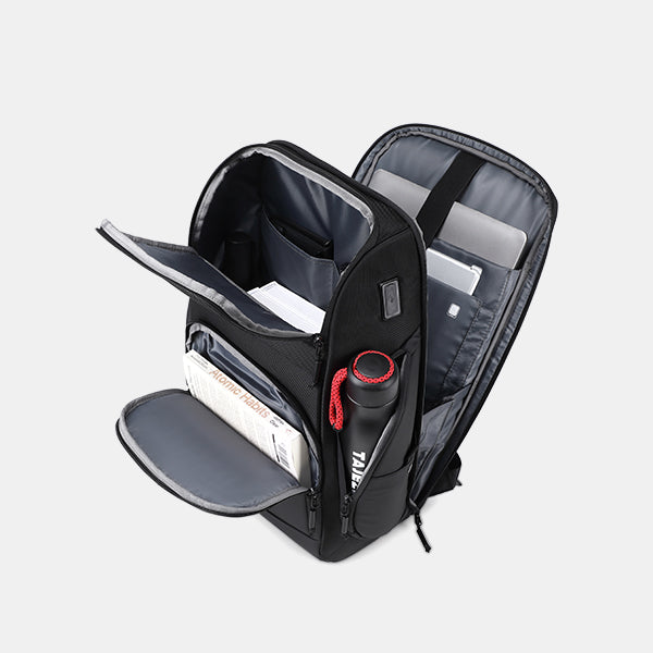 Black backpack with compartments on a light gray background