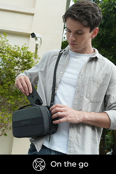 A person placing a smartphone into the TechPouch digital organizer.