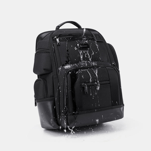 Black backpack with water splashes on a light gray background