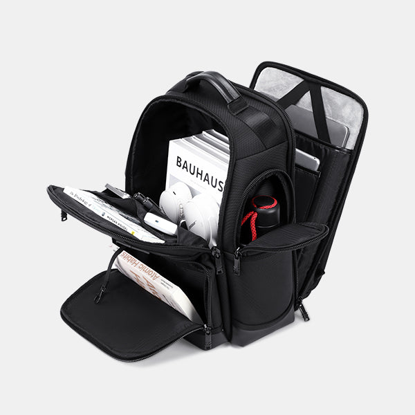 Black backpack with compartments containing books and a helmet on a white background