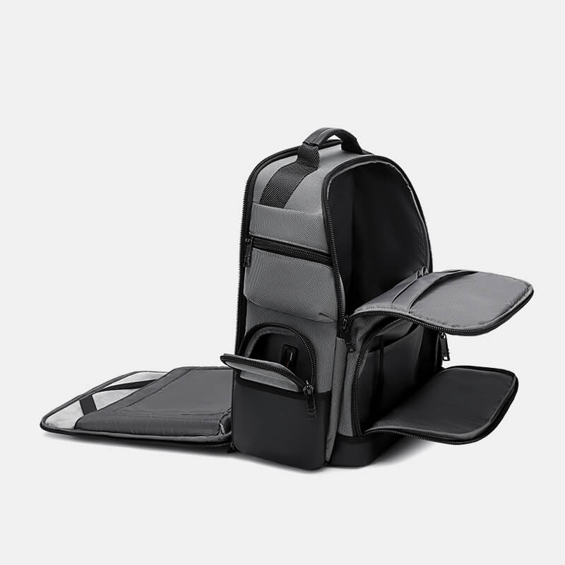 Black and gray backpack with open compartments on a light gray background