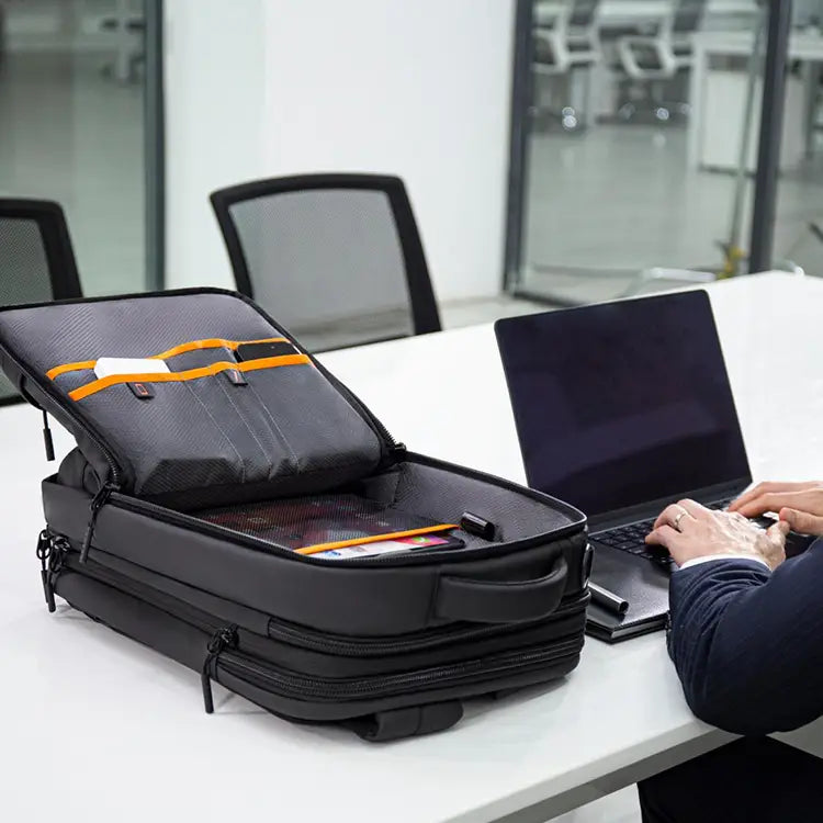 Open Cinomadist travel backpack beside a laptop on an office desk