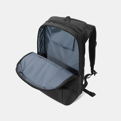 Black backpack with open front compartment on a light gray background
