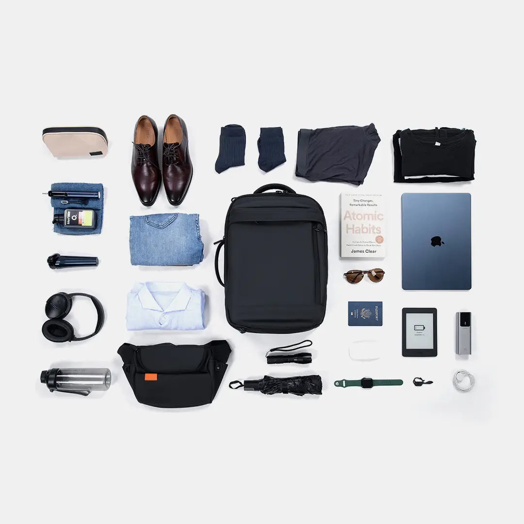 Flat lay display showing the extensive packing capacity of the Travel Expandable Backpack Pro with clothes, a laptop, and daily essentials.