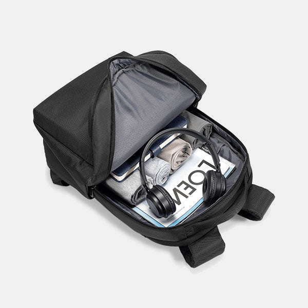 Black backpack with open compartment showing a laptop, water bottle, and headphones on a light gray background