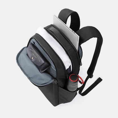 Black backpack with compartments containing a laptop, phone, and other items on a light gray background