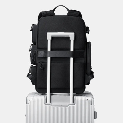 Black training backpack mounted on luggage trolley sleeve for travel