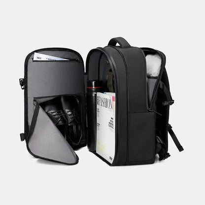 Black backpack with compartments and items inside on a white background