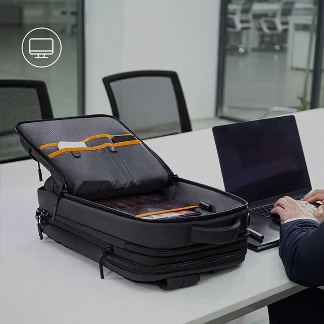Black travel bag with laptop on a desk in an office setting
