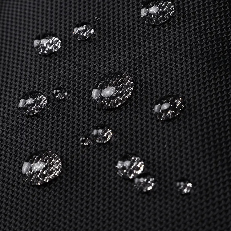 Water droplets beading on black technical fabric used for Cinomadist travel bags