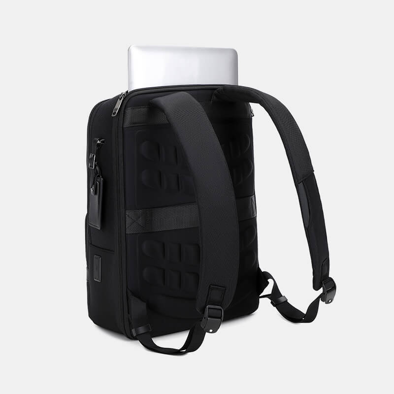 Black backpack with a laptop inside on a light gray background