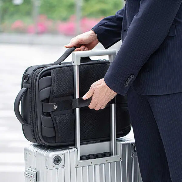 Cinomadist backpack securely attached to a suitcase handle with a luggage strap