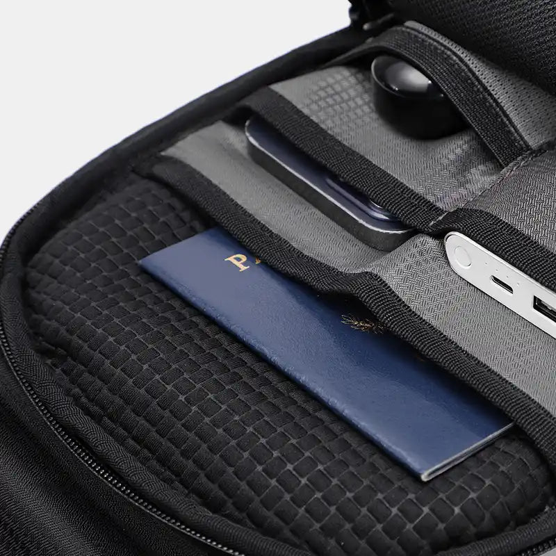 Black travel bag with a passport inside, on a light gray background