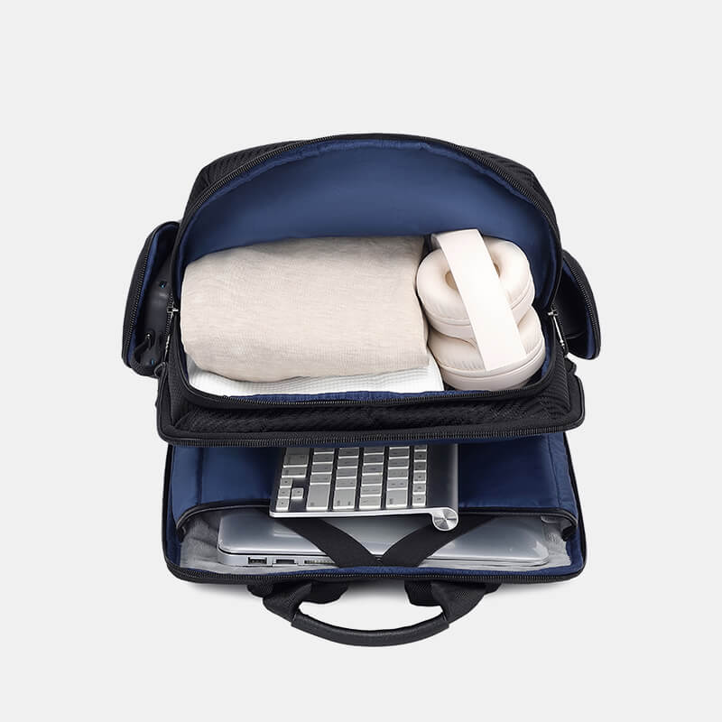 Navy blue backpack with a laptop and rolled-up items on a light gray background