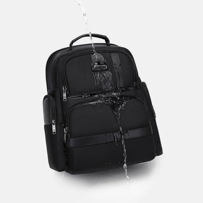 Black backpack with water splashing onto it on a white background