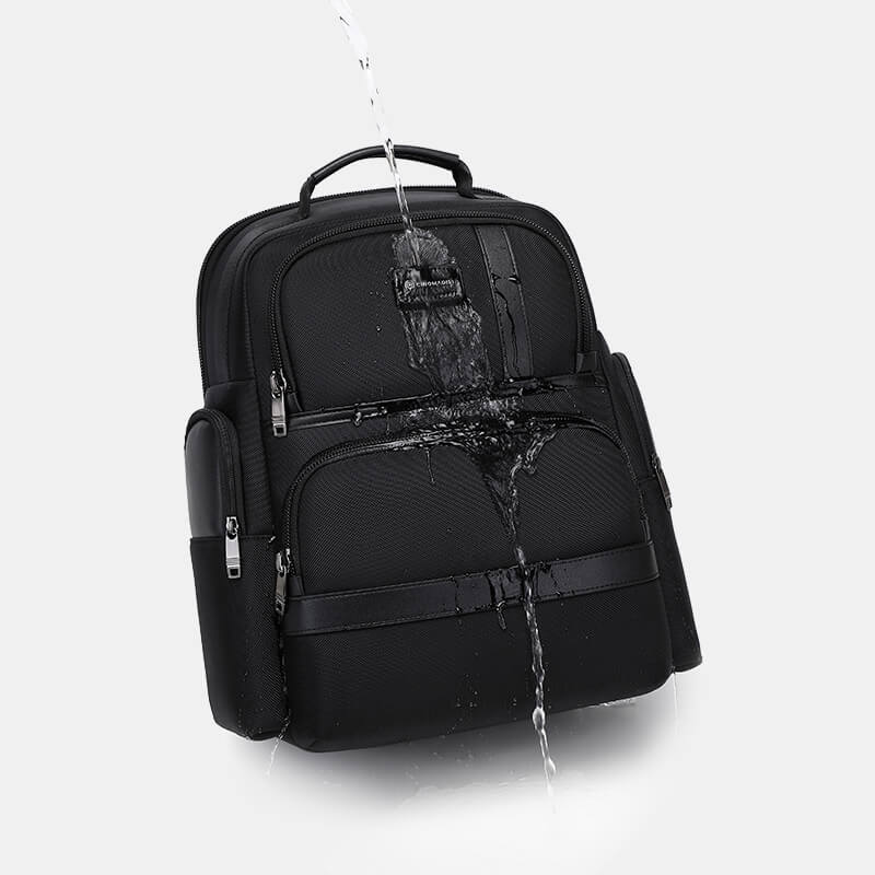 Black backpack with water splashing onto it on a white background