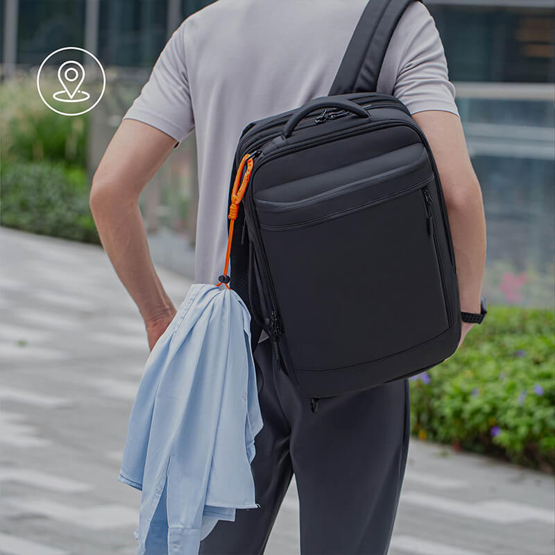 Man sightseeing with backpack; orange buckle secures a jacket for hands-free carry