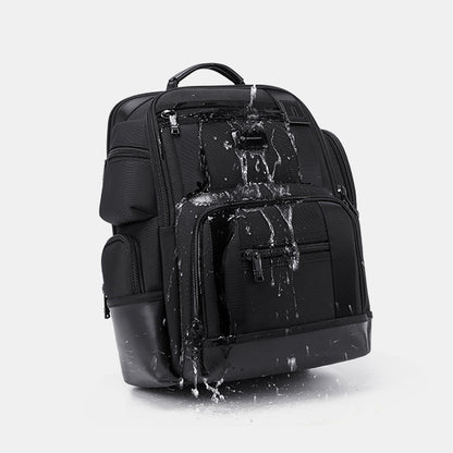 Black backpack with water splashes on a light gray background