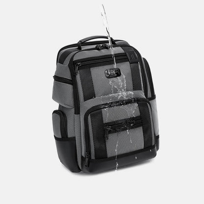 Gray and black backpack with water splashes on a light gray background