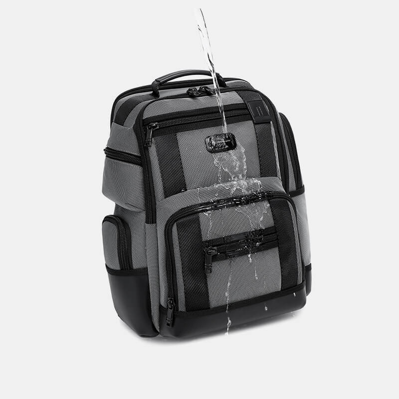 Gray and black backpack with water splashes on a light gray background